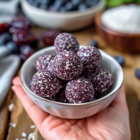 A bowl of dark chocolate balls with nuts on top.